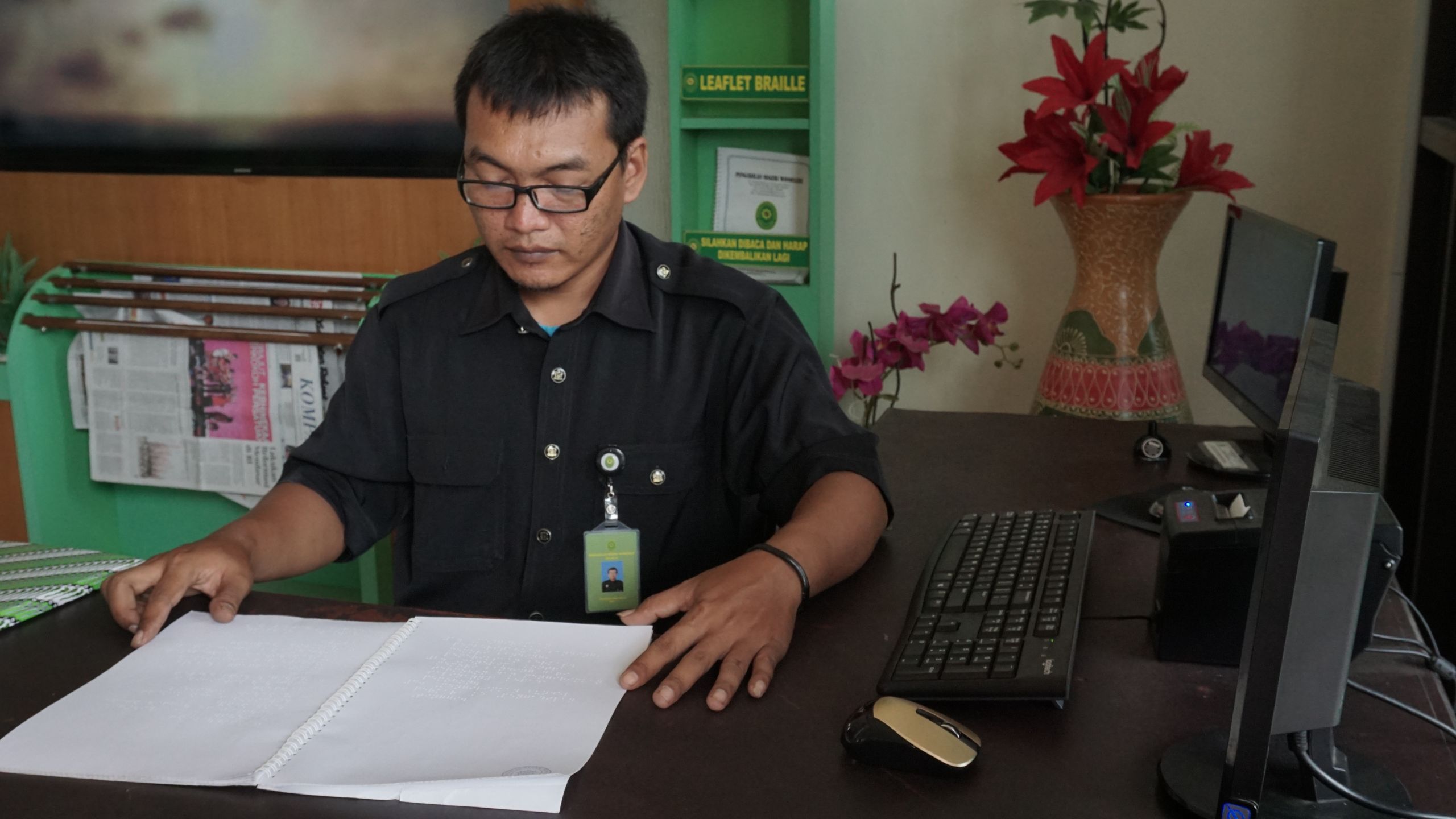A court staff reads documents in Braille.